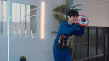 a man in a blue sweatshirt is holding a red frisbee with a korean flag on it