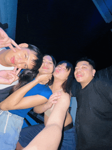 a group of people posing for a picture and one of them is wearing a black shirt