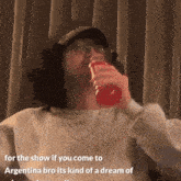 a man drinking from a red bottle with the words for the show if you come to argentina bro