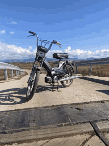 a black and silver motorcycle with the word triumph on the front is parked on the side of a road