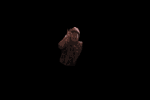 a man wearing a red hat and a leopard print shirt is giving a peace sign