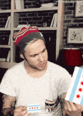 a man in a white shirt is holding a chicago flag in his hands