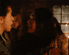 a man and a woman are talking in a dark room