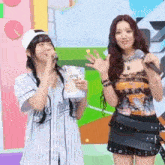 two women are standing next to each other on a stage holding microphones .