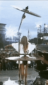 a woman playing drums in front of a crowd of people
