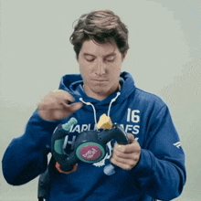 a man wearing a blue hoodie that says 16 on it