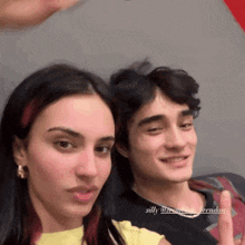 a man and a woman are posing for a picture with the man giving the middle finger