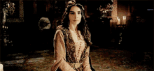 a woman in a fancy dress is sitting in a room with candles