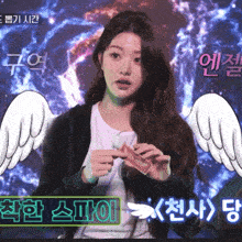 a woman with angel wings is holding a card in front of a foreign language sign