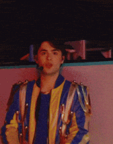 a man wearing a blue and yellow jacket and a microphone