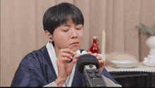 a person wearing a blue robe is holding a boombox