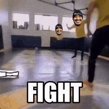 two men are dancing in a gym and the word fight is on the floor in front of them