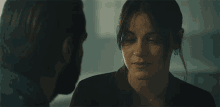 a man and woman are looking at each other and the woman is smiling