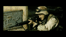 a man in a military uniform is holding a gun in front of a wall with arabic writing on it that says p9