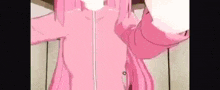 a girl in a pink jacket is standing in front of a wall .