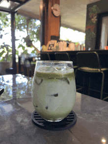 a green drink in a glass on a table