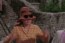 a young girl wearing a plaid shirt and a straw hat .