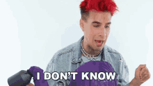 a man with red hair is holding a purple jacket that says i don 't know
