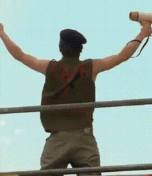 a man holding a megaphone with his arms outstretched in the air