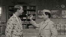 a man in a military uniform talks to another man