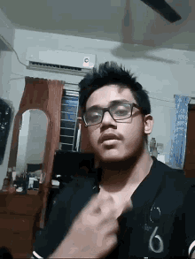 a young man wearing glasses and a shirt with the number 6 on it