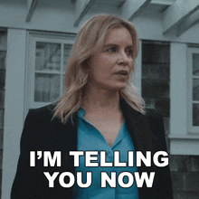a woman says i 'm telling you now while standing in front of a house