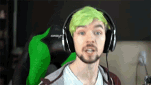 a man with green hair and a beard wearing headphones