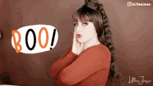 a woman stands in front of a sign that says boo !
