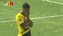 a soccer player in a yellow and black jersey with the letter j on it
