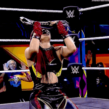 a woman in a wrestling ring is wearing a belt that says 10 shira on it