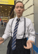 a man wearing suspenders and a tie says theatre on his shirt