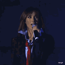 a woman singing into a microphone with rbd.gif at the bottom of the screen