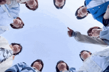 a group of people are standing in a circle and one of them is pointing at the sky
