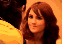 a woman with red hair is smiling and looking at another woman .