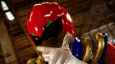 a person wearing a red helmet is being held by another person