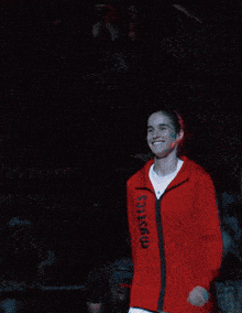 a woman wearing a red jacket that says boston on it