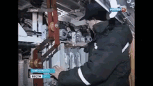 a man is working on a machine with a sign in the background that says ' russia '