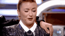 a woman in a sequined jacket is crying while a man holds her shoulder