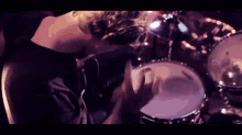 a man in a black shirt is playing drums