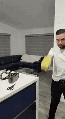 a man is standing in a living room holding a tape measure .