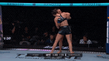 two women are fighting in a boxing ring with 1:28 left