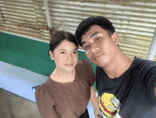 a man and a woman are posing for a picture and the man is wearing a t-shirt with a burger on it
