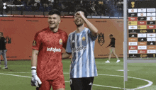 two men on a soccer field one wearing a blue and white jersey that says infojobs