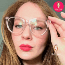 a close up of a woman wearing glasses with a logo for lillee jean productions behind her