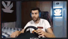 a man wearing headphones is sitting in front of a computer monitor eating a snack .