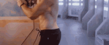 a man is standing in front of a mirror without a shirt on .
