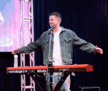 a man stands in front of a keyboard that says nord stage 3