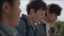 a group of young people are standing next to each other and one of them is wearing a backpack