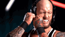 a man with a tattoo on his arm is wearing headphones and making a funny face