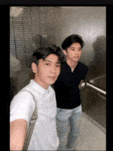 two young men standing next to each other in a elevator